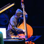 A student wearing a knitted hat plays a double bass