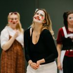 A group of students perform wearing clown make up
