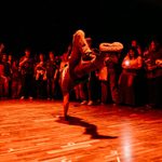 A man is breakdancing in the midst of a circle of people.